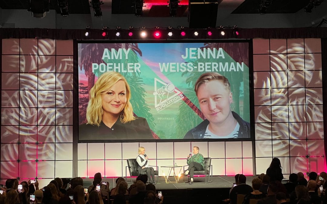 audience with two people in chairs on stage
